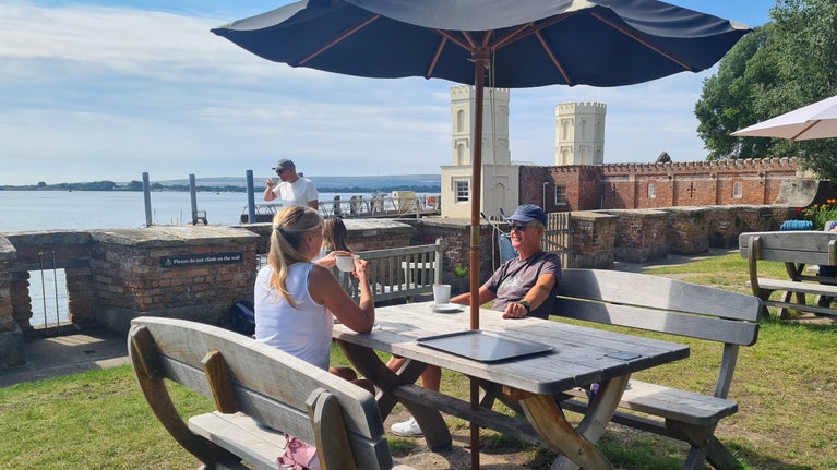 Couple sitting in the Villano Café garden with views over Poole Harbour.